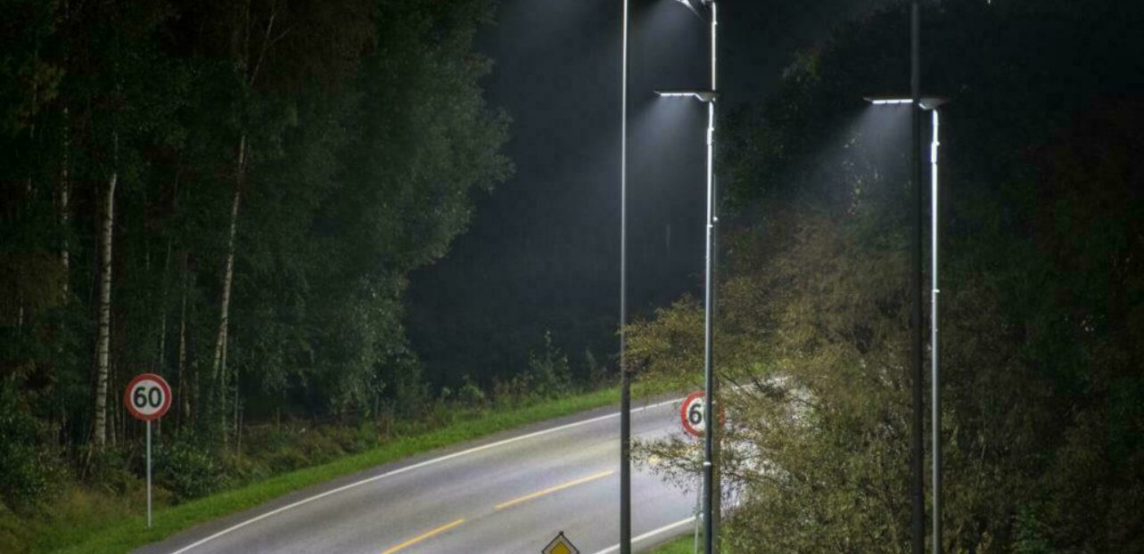 Gatelys som lyser opp en vei sving med skiltet 60kmt.